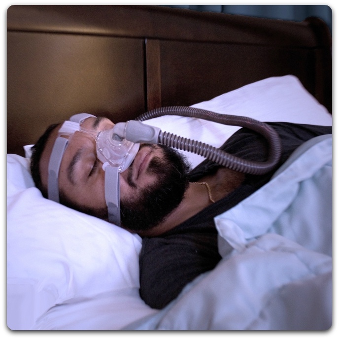 Man sleeping in bed using PAP treatment